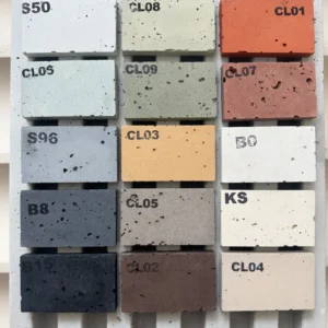 Farbmusterbox mit verschiedenen Betonfarben und Kennzeichnungen wie S50, CL08, CL01, B15. Die Farbpalette reicht von Weiß über Grau und Braun bis hin zu Orange und Grün.