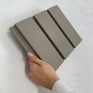 Nahaufnahme eines Roca Moonlight Grey Wandpaneels, gehalten in einer Hand. Das Paneel zeigt eine strukturierte Oberfläche und ist für die akustische Wandgestaltung geeignet. Ideal für moderne Raumkonzepte.