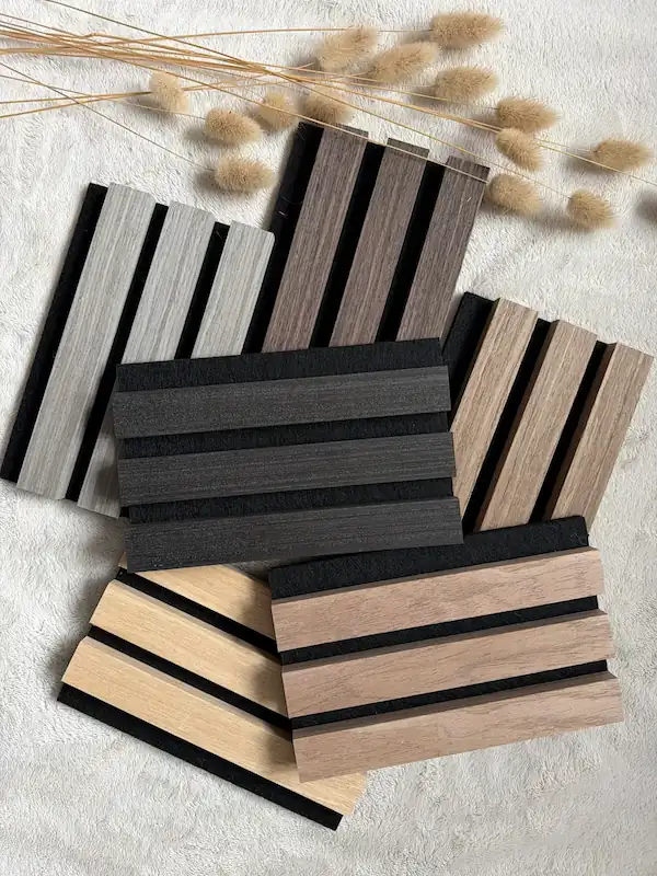 Auswahl an dekorativen Wandpaneelen (Lamellen) in Eiche, Esche und Dunkelgrau auf schwarzem Filzuntergrund.